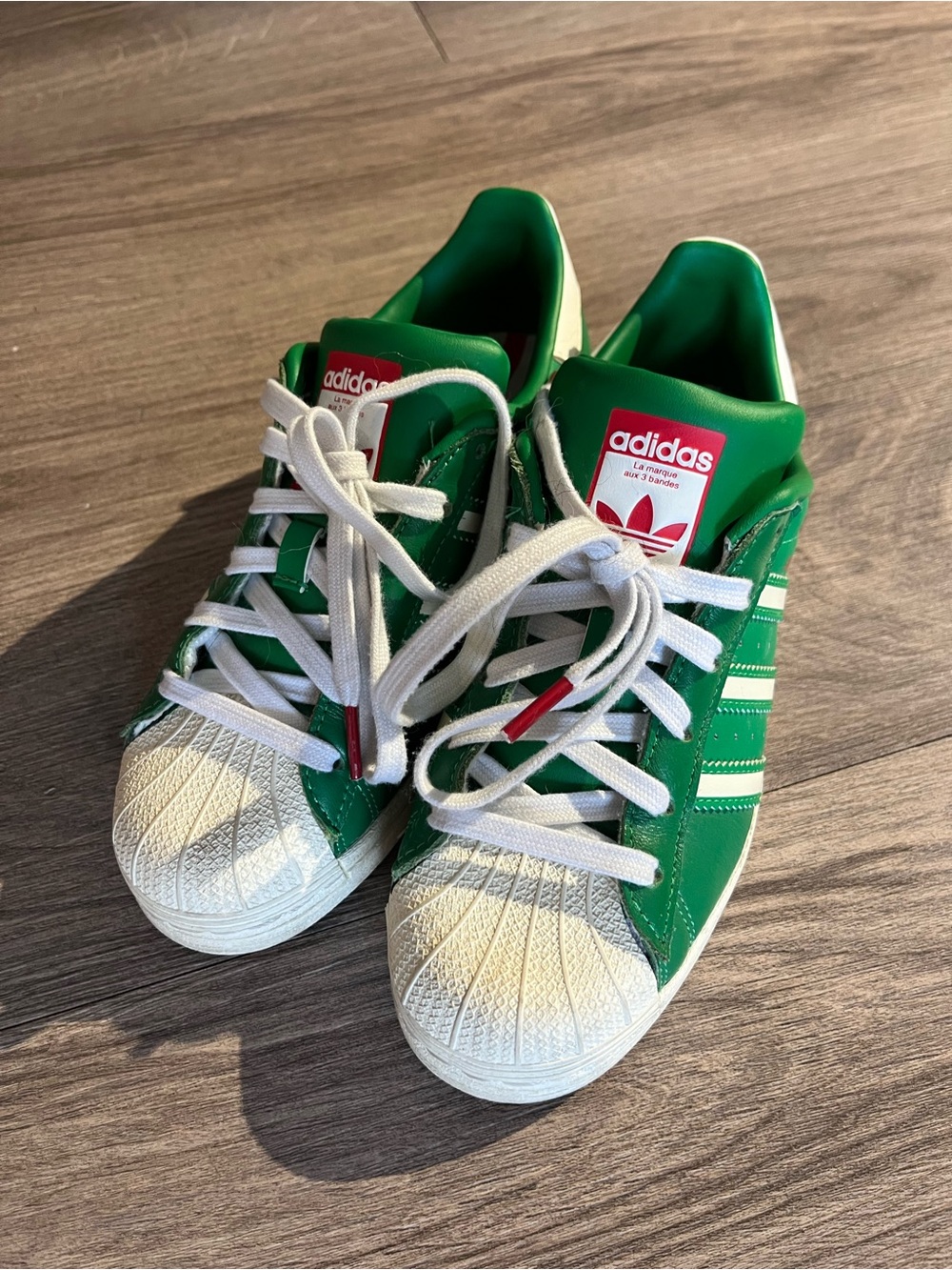 adidas women’s Green and White Superstar Sneakers with Red Logo